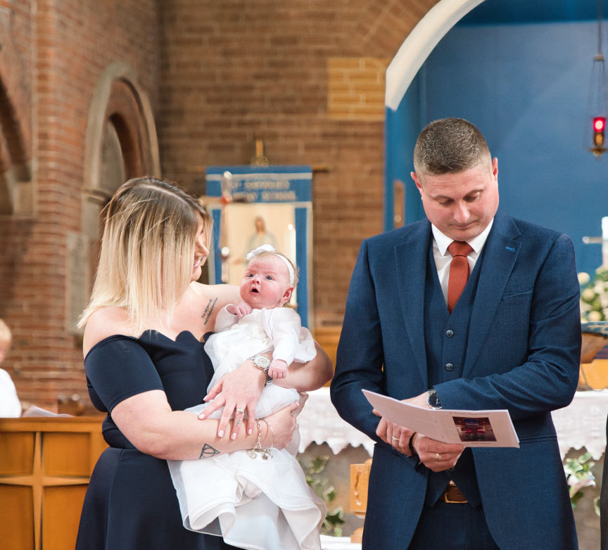 Mother and father with baby at christening